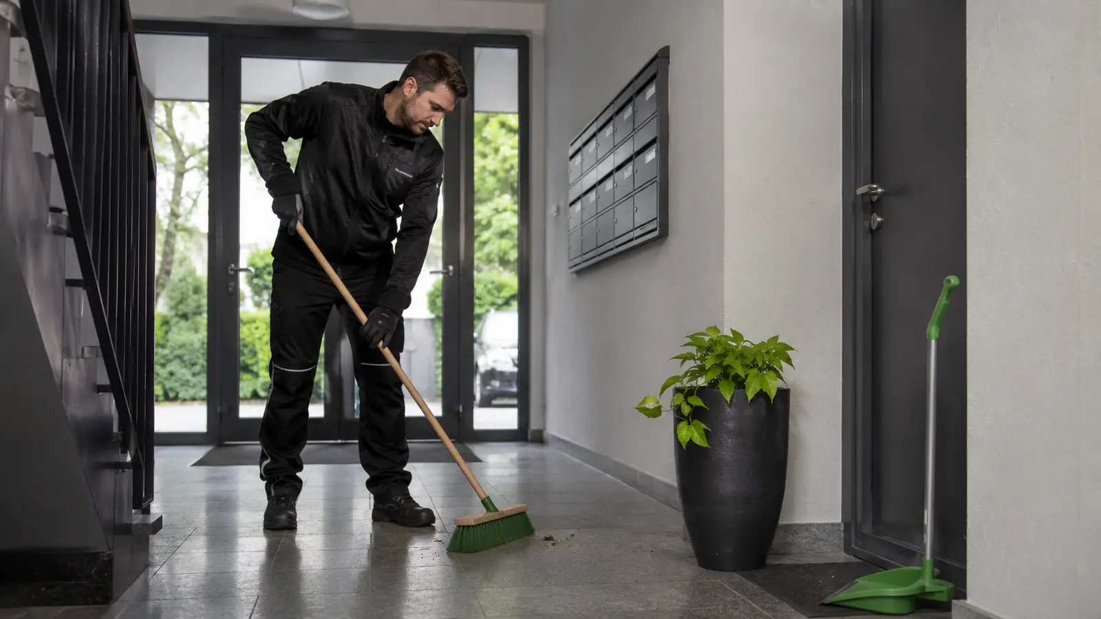 Mitarbeiter bei der Kehrwoche und Reinigung eines gepflegten Eingangsbereichs